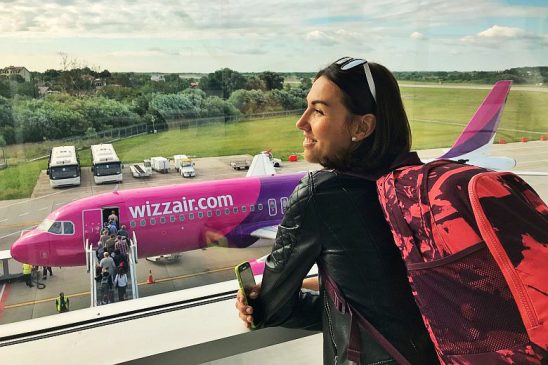 Utasok beszállásának megtekintése egy Wizz Air repülőgépbe egy repülőtéri terminál ablakán keresztül.